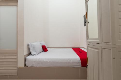 棉兰RedDoorz near UISU teladan Medan的一间小卧室,配有一张带红色毯子的床