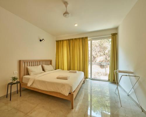 OxelFig House Anjuna-Chapora Road , Siolim 1BHK Suite的一间卧室设有一张床和一个大窗户