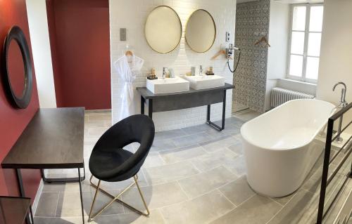 BernesqChâteau de Bernesq的浴室设有两个盥洗盆和一张黑椅子