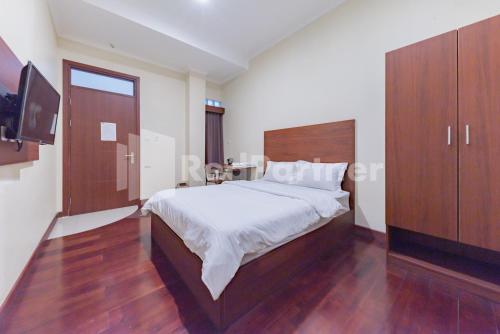 万隆Maleo Residence Bandung Mitra RedDoorz的一间带大床和电视的卧室