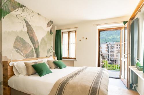 奥斯塔Aosta Holiday Apartments - Sant'Anselmo的一间卧室设有一张大床和一个大窗户
