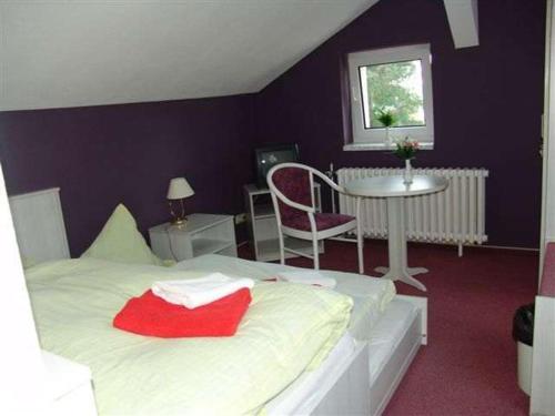布科马克思赫瑞士餐厅&酒店的卧室配有白色的床、桌子和窗户。