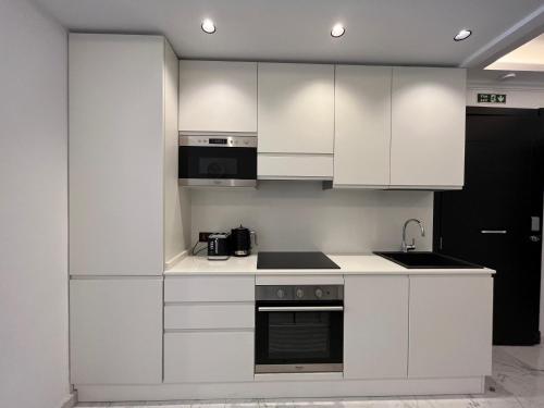 姆西达Msida Marina Apartments的厨房配有白色橱柜和炉灶烤箱。