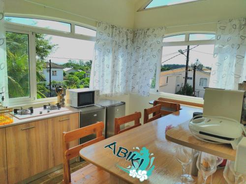 阿尔比恩Maya-Abiki Mauritius的厨房以及带桌子和窗户的用餐室。