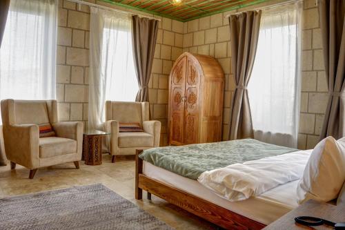内夫谢希尔IVY Cappadocia的一间卧室配有一张床和两把椅子