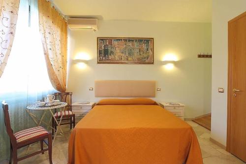 佛罗伦萨Arcadia GuestHouse的一间卧室配有一张带橙色毯子的床