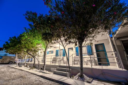 利萨基亚Zante Riva Studios的一座建筑前面有蓝色的窗户和树木