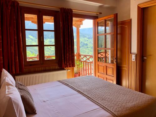 美特索文Apostolos Hotel的一间卧室设有一张床和一个大窗户