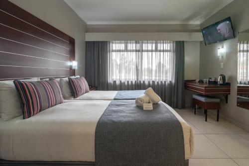 乌姆塔塔萨沃伊酒店和会议中心的酒店客房设有一张大床和一张书桌。