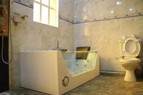 纳库鲁Brooks Lodge的带浴缸、卫生间和盥洗盆的浴室