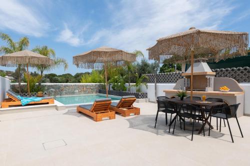 法里拉基Aqua Villa Faliraki的一个带桌椅的庭院和一个游泳池