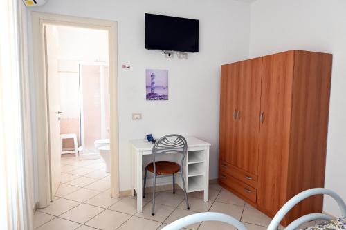 毕博纳的码头Affittacamere I Gigli di Mare的客房设有书桌和墙上的电视。