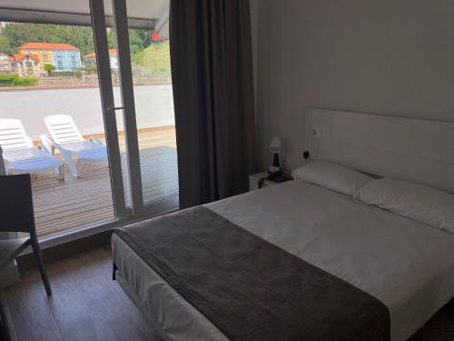 桑坦德Eurocity Hotel Santander Centro的一间卧室设有一张床和一个美景阳台