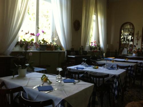 博纳索拉佩西恩摩德纳酒店的用餐室配有带白色桌布的桌子,并可能令客人感到不安