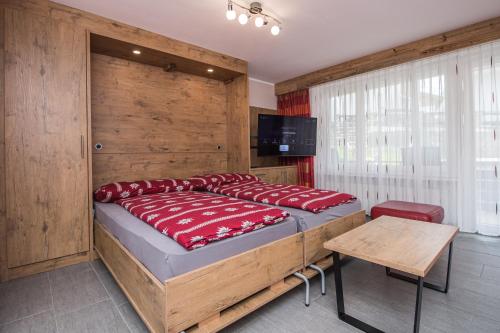 采尔马特弗勒洛普公寓的一间卧室设有一张大床和木墙