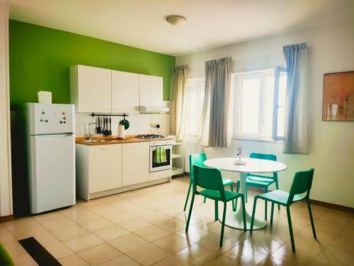 莫诺波利Il Mare di Giò的厨房配有桌椅和白色冰箱。