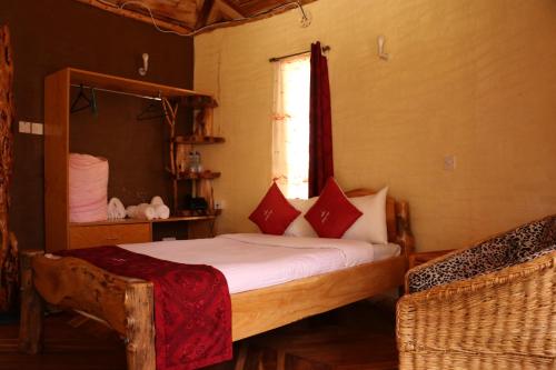 纳库鲁Brooks Lodge的一间卧室配有一张床、两把椅子和一个窗户