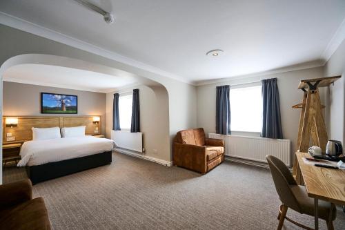 RuffordRed Lion, Wigan by Marston's Inns的酒店客房配有一张床、一把椅子和一张书桌