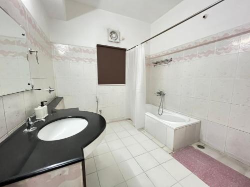 海得拉巴BedChambers Serviced Apartments的浴室配有盥洗盆和浴缸。