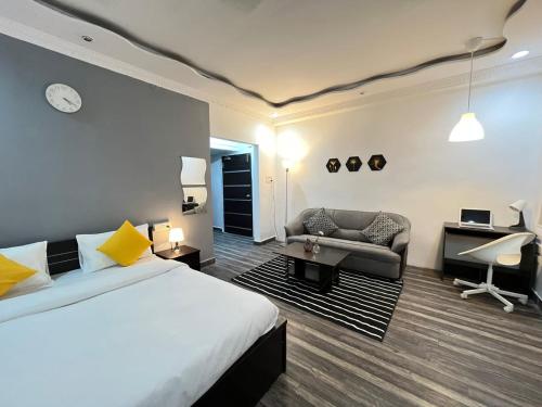 海得拉巴BedChambers Serviced Apartments的一间卧室配有一张床、一张沙发和一张书桌