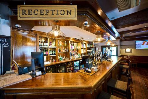 RuffordRed Lion, Wigan by Marston's Inns的酒吧里的酒吧,上面有读接待处的标志