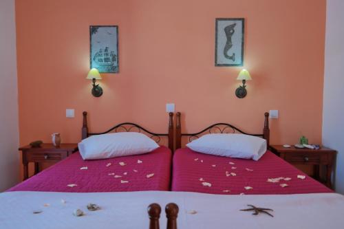 纳克索乔拉扎非里一室公寓的卧室设有两张粉红色的床铺。