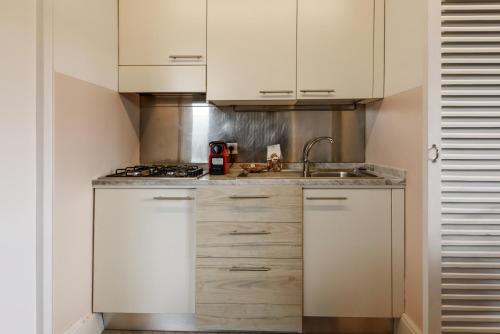 佛罗伦萨Casa Barontini的厨房配有白色橱柜和水槽