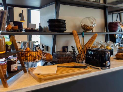 洛里昂洛里昂中心美居酒店的厨房柜台,提供面包和食物篮