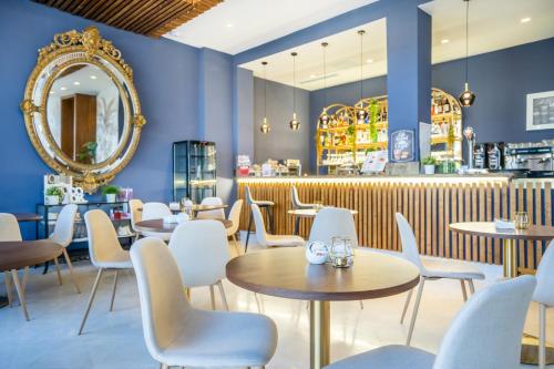 加的斯加的斯广场Spa酒店的餐厅拥有蓝色的墙壁和桌椅