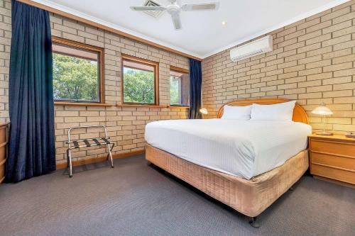 阿德莱德松布列罗康福特茵套房酒店的一间卧室设有一张大床和两个窗户。