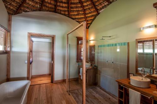 Massinga玛辛加海滩山林小屋的带淋浴、盥洗盆和卫生间的浴室