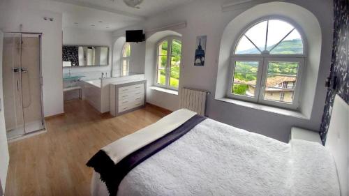 TudancaAlojamiento rural El Refugio的一间卧室设有一张大床和两个窗户。