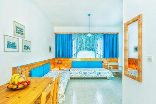 波塞蒂Xenios Faros Apartments的一间卧室配有一张床和一张桌子及一碗水果
