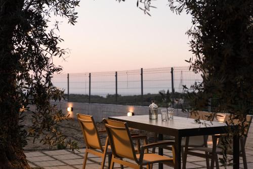 马鲁拉斯Mela Luxury Apartments的桌椅、桌子和围栏