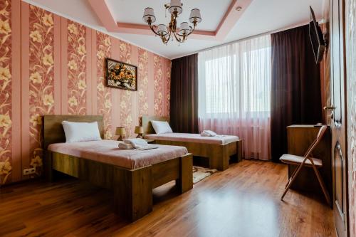 基辅Poznyakoff Aparthotel的一间卧室配有两张床和吊灯。
