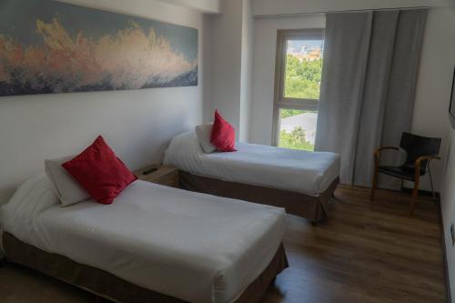 门多萨门多萨莫德酒店的酒店客房设有两张床和窗户。