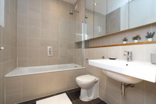 伦敦Award Winning 2 Bedroom House, King's Cross的浴室配有盥洗盆、卫生间和浴缸。