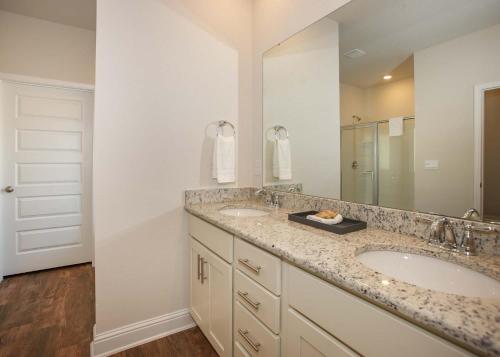 弗利Luxury Getaway House的一间带两个盥洗盆和大镜子的浴室