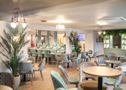 米尔福德昂西Shorefield Country Park的一间带桌椅的餐厅和一间酒吧