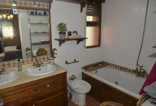 加拉帕加尔LA CASA DE GALAPAGAR ALOJAMIENTO SIETE PICOS的浴室配有盥洗盆、卫生间和浴缸。