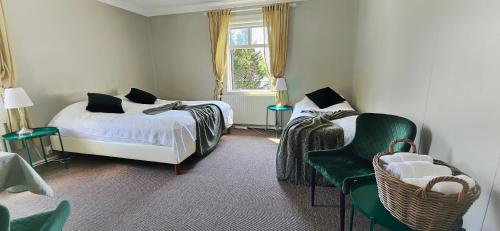 胡萨维克阿波尔旅馆的一间卧室设有两张床、一把椅子和一个窗户。