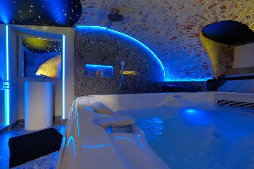 蒙斯Secret Jacuzzi Mons - Parking privé gratuit的浴室配有蓝色照明的浴缸