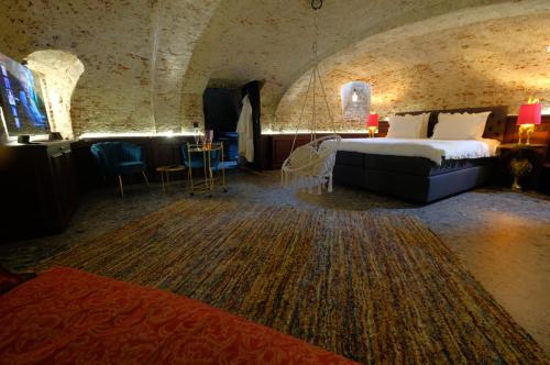 蒙斯Secret Jacuzzi Mons - Parking privé gratuit的酒店客房带一张床、一张桌子和椅子