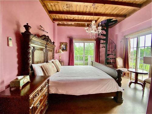 五结英格兰小古堡的一间卧室配有一张大床和一个吊灯。