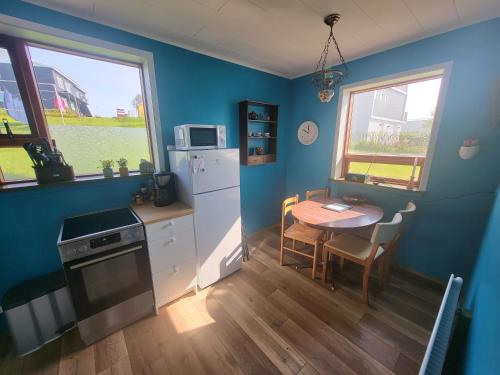 HríseyÁsgarður的厨房配有桌子和白色冰箱。