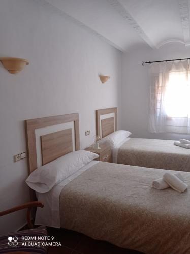莱图尔Casa Rural Juan, el Zapa的酒店客房设有两张床和窗户。