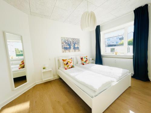 腓特烈港aday - Luminous apartment with 2 bedrooms的卧室配有白色的床和镜子