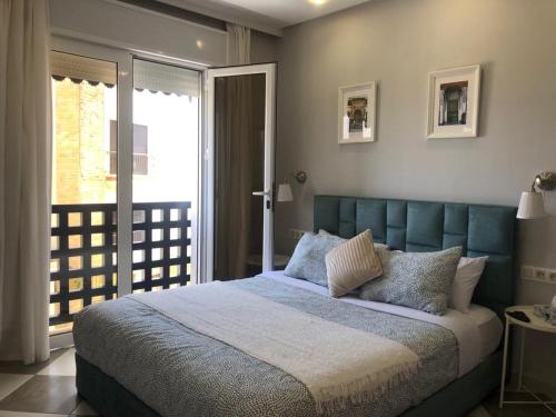 艾西拉casa bahia的一间卧室配有一张大床和蓝色床头板