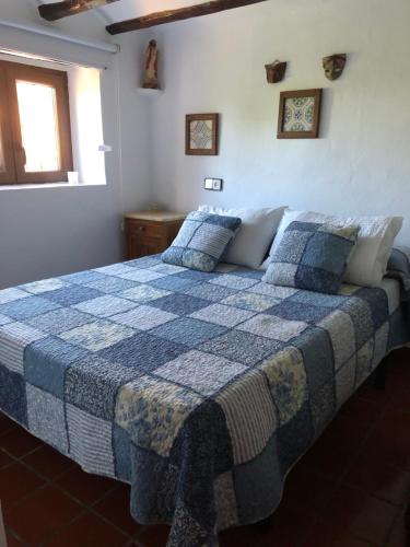 比拉法梅斯El Refugi的一间卧室配有一张带蓝白色毯子的床