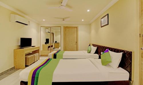 加尔各答Treebo Trend ASL Prime的酒店客房设有两张床和电视。